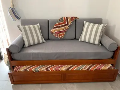 a gray couch with two pillows on top of it at Açoteias Falésia Studio Apartment in Olhos de Água