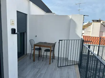 a small balcony with a wooden table and chairs at Casa Susana in Faro