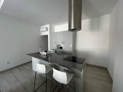 a kitchen with a black counter and white walls at Casa Susana in Faro