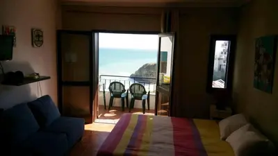 a bedroom with a bed and a balcony with a view at T0 close to the beach and the city center in Albufeira