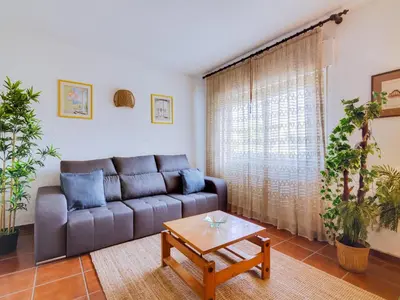 a living room with a couch and a coffee table at Apartamento Forte Novo no centro de Quarteira in Quarteira
