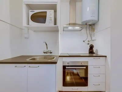 a small kitchen with a sink and a microwave at Apartamento Forte Novo no centro de Quarteira in Quarteira