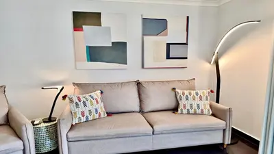 a living room with a couch and some paintings at Monte Verde A,Lar Linda - CD 293 Cleverdetails, Sleeps 2 adults and 2 children, 4 salted water pools in Quarteira