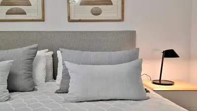 a bedroom with a bed with white pillows and a lamp at Monte Verde A,Lar Linda - CD 293 Cleverdetails, Sleeps 2 adults and 2 children, 4 salted water pools in Quarteira