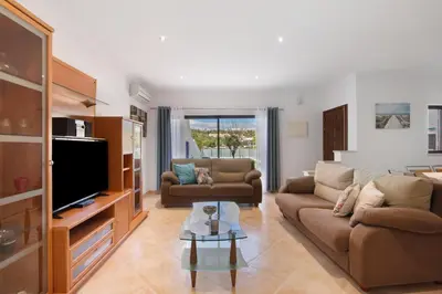 a living room with a couch and a tv at Villa Neves in Albufeira