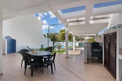 a dining area with a table and chairs on a patio at Villa Neves in Albufeira