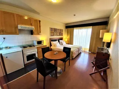 a room with a bed and a kitchen with a table at Hotel Vila Galé Cerro Alagoa in Albufeira