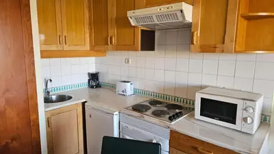 a kitchen with a stove and a microwave at Hotel Vila Galé Cerro Alagoa in Albufeira