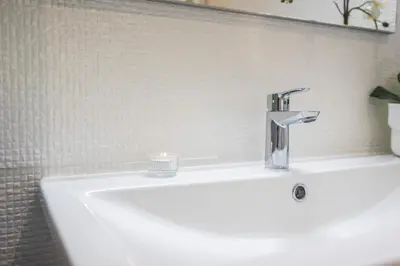 a white bathroom sink with a candle on it at Terracos de Quarteira Orange by Real Properties in Quarteira