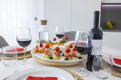 a table with a plate of food and wine glasses at Terracos de Quarteira Orange by Real Properties in Quarteira