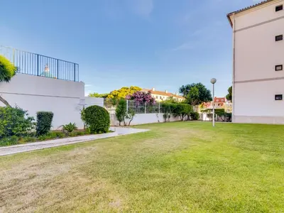 a grassy yard next to a white building at AL Vilamoura Porto Marina in Vilamoura