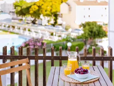 a table with two glasses of orange juice and a bowl of fruit at AL Vilamoura Porto Marina in Vilamoura