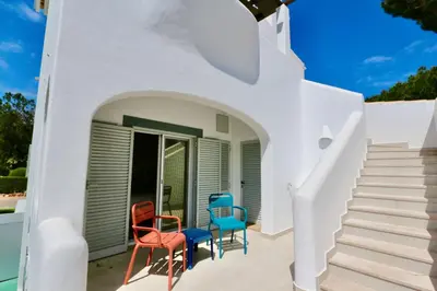 a group of chairs sitting on the front porch of a house at Monte Verde B CD 294 - Cleverdetails, Sleeps 2 adults and 2 children, 4 salted water pools in Quarteira