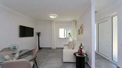 a living room with a couch and a table at Monte Verde B CD 294 - Cleverdetails, Sleeps 2 adults and 2 children, 4 salted water pools in Quarteira
