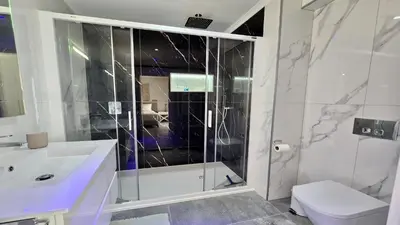 a bathroom with a shower and a toilet and a sink at Monte Verde B CD 294 - Cleverdetails, Sleeps 2 adults and 2 children, 4 salted water pools in Quarteira