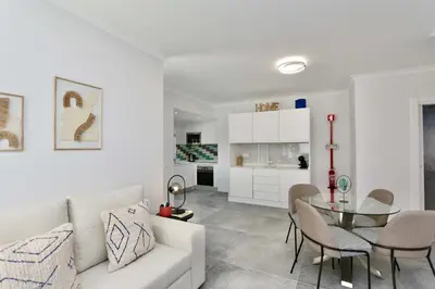 a living room with a white couch and a glass table at Monte Verde B CD 294 - Cleverdetails, Sleeps 2 adults and 2 children, 4 salted water pools in Quarteira