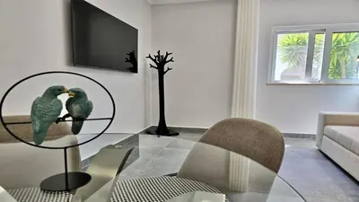 two birds sitting on a glass table in a living room at Monte Verde B CD 294 - Cleverdetails, Sleeps 2 adults and 2 children, 4 salted water pools in Quarteira