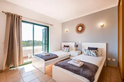 a bedroom with two beds and a large window at Villa Lamella in Albufeira