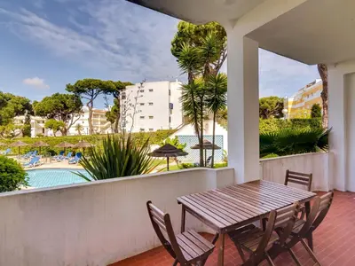 a balcony with a table and chairs and a swimming pool at Apartamento Alvaflor com Piscina – Vilamoura in Quarteira