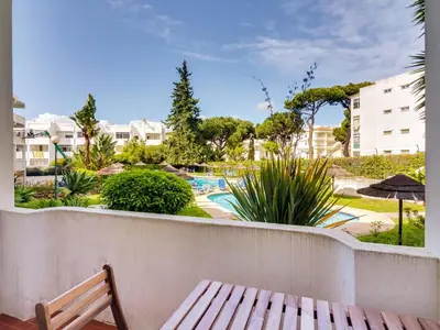 a balcony with a bench and a swimming pool at Apartamento Alvaflor com Piscina – Vilamoura in Quarteira