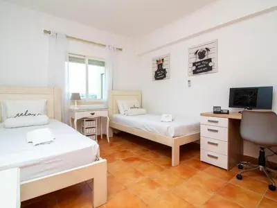 a bedroom with a bed and a desk with a computer at Quinta do Paiva Apartment by Stay ici Algarve Holiday Rental in Albufeira
