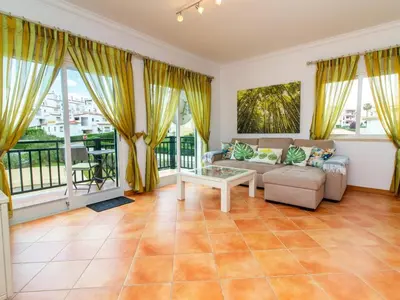 a balcony with a table and chairs and a swimming pool at Quinta do Paiva Apartment by Stay ici Algarve Holiday Rental in Albufeira