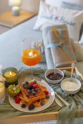 a table with a plate of food and a glass of orange juice at Moradia Flaj in Olhos de Água