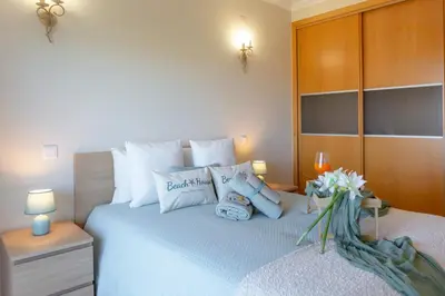 a bedroom with a large bed with white pillows at Moradia Flaj in Olhos de Água
