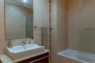a bathroom with a sink and a mirror and a tub at Moradia Flaj in Olhos de Água