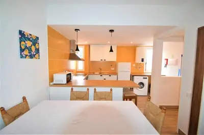 a kitchen with a table and a counter top at Casa das Areias in Albufeira