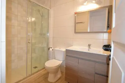 a bathroom with a toilet and a shower and a sink at Casa das Areias in Albufeira