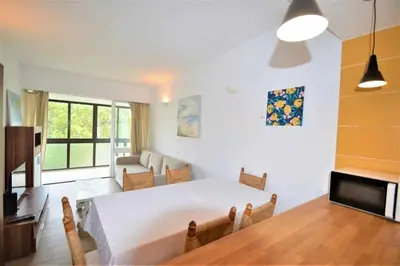 a living room with a large white table and chairs at Casa das Areias in Albufeira