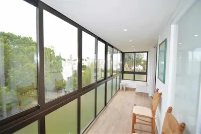 an empty room with large windows and chairs at Casa das Areias in Albufeira