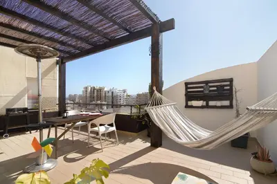 two hammocks on a balcony with a view of a city at Algarve Apartment, Faro - Excellent Location in Faro
