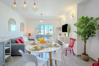 a dining room and living room with a table and chairs at Albufeira Old Town Sea View Apartment in Albufeira