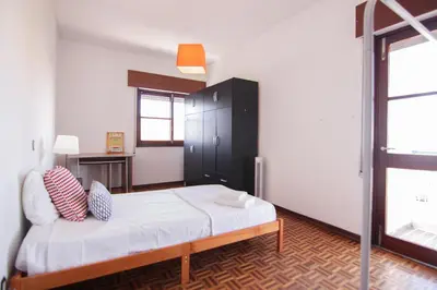 a bedroom with a bed and a black cabinet at 4 Bedroom in Faro Downtown in Faro