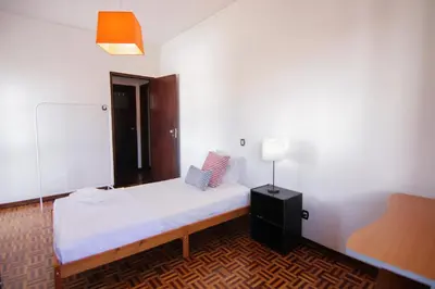 a small room with a bed and a lamp at 4 Bedroom in Faro Downtown in Faro