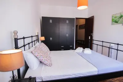 a bedroom with a bed with a black headboard at 4 Bedroom in Faro Downtown in Faro
