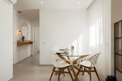 a dining room with a glass table and chairs at The Marina Collection in Quarteira