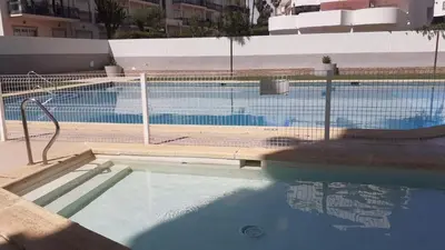 a large swimming pool with a fence around it at Caranguejo Apartment in Albufeira