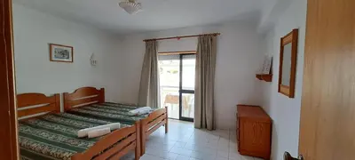 a bedroom with two twin beds and a window at Caranguejo Apartment in Albufeira