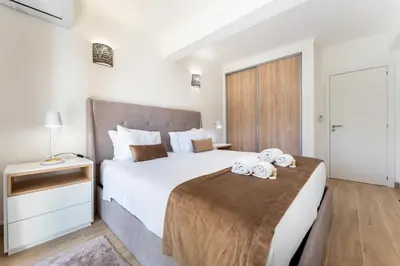 a bedroom with a large bed with towels on it at Apartamento Pine by Algarve Holidays in Roja- Pé