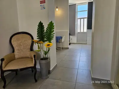 a hallway with a chair and a potted plant at Blife Montya private rooms in Faro