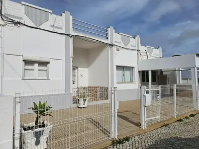 a white house with a fence in front of it at Blife Montya private rooms in Faro