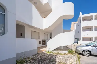 a white house with white stairs in front of it at Seaside Charm Flat w/ Balcony by HostWise in Albufeira