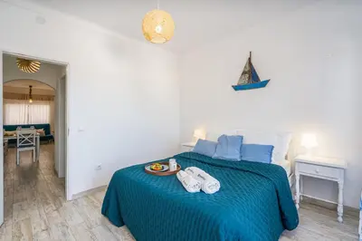 a bedroom with a blue bed with a tray of food on it at Seaside Charm Flat w/ Balcony by HostWise in Albufeira