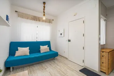a blue couch in a room with a closet at Seaside Charm Flat w/ Balcony by HostWise in Albufeira
