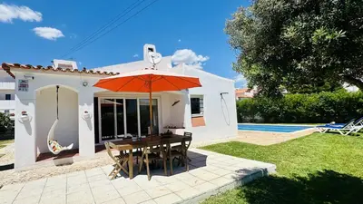 a table with an umbrella in front of a house at Strip II by Check-in Portugal in Albufeira