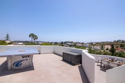a patio with a table and chairs on a balcony at Villa Rose in Albufeira