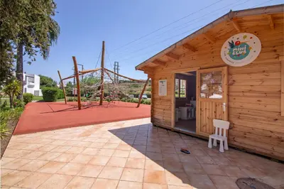 a small wooden building with a playground in the background at Villa Rose in Albufeira